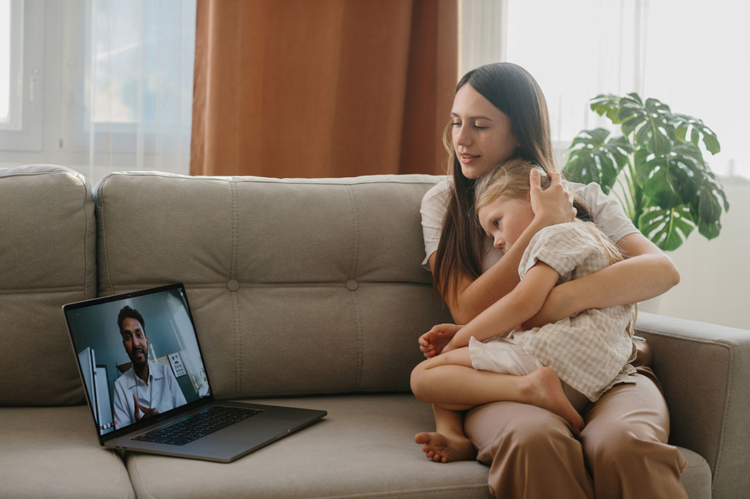 A mother and her young daughter having a video consultation with a Night Doctor GP at home